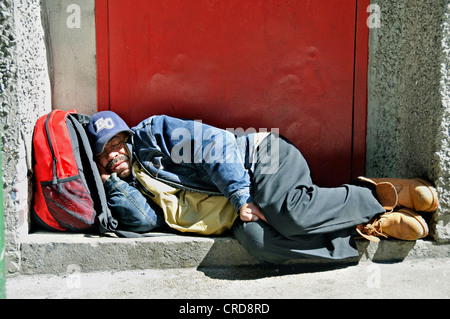 Une personne sans-abri dort sur un escalier, USA, New York, Manhattan Banque D'Images