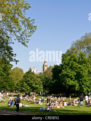 Foules bronzer et se détendre dans le St James Park avec Big Ben en arrière-plan l'Europe Angleterre Londres Banque D'Images