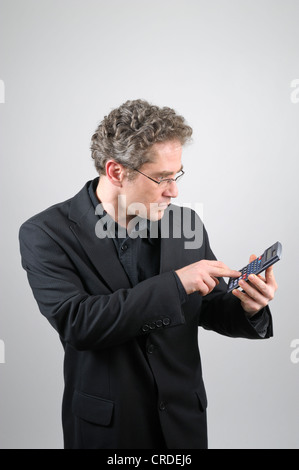 Businessman portant un costume noir tenant une calculatrice Banque D'Images