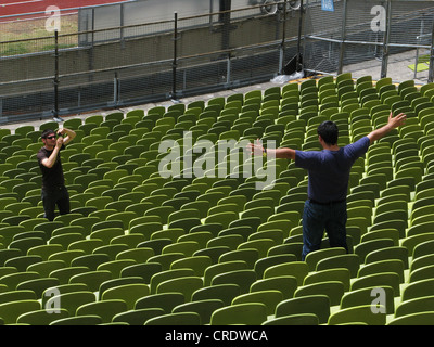 Stade olympique de Munich, l'homme est photographiée entre les sièges, l'Allemagne, Bavaria, Munich Banque D'Images