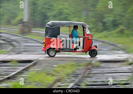 Trois-roues dans heavy rain, passage à niveau de Kalawewa, Sri Lanka, Ceylan, l'Asie du Sud, Asie, PublicGround Banque D'Images