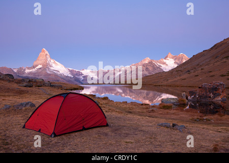 Au début de la campagne tente rouge la lumière du matin sur le lac Stellisee surplombant le Mont Cervin, Zermatt, Valais, Suisse, Europe Banque D'Images