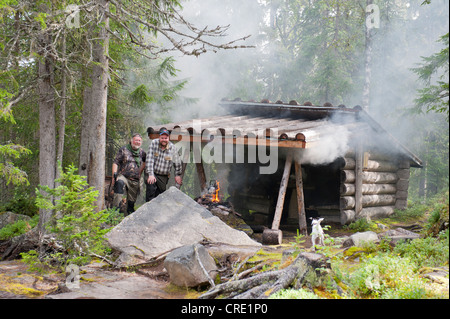 Les travailleurs forestiers et les chasseurs suédois faire le café sur un incendie dans une cabane dans les bois, près de l'Fulufjaellets National Park Banque D'Images