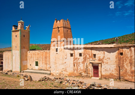 Mosquée islamique avec un minaret et une partie de la Casbah, boue, forteresse berbère résidentiel château, Tighremt, village de Ait Ourhaine Banque D'Images