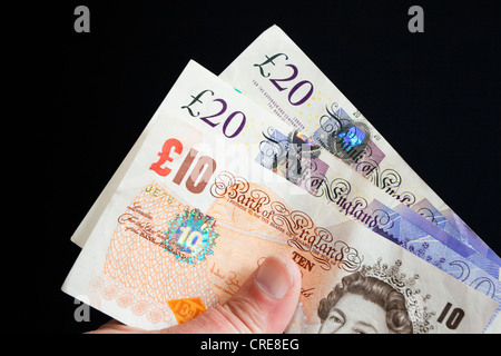 Livre Stirling notes dans la main Banque D'Images