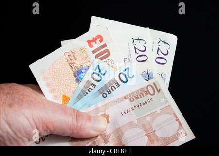 Livre Stirling et billets d'euros à la main Banque D'Images