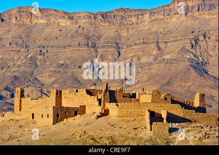 Kasbah en ruine sur une colline, une ancienne maison des Berbères d'adobe, de montagnes du djebel Kissane Table Mountain à l'arrière Banque D'Images