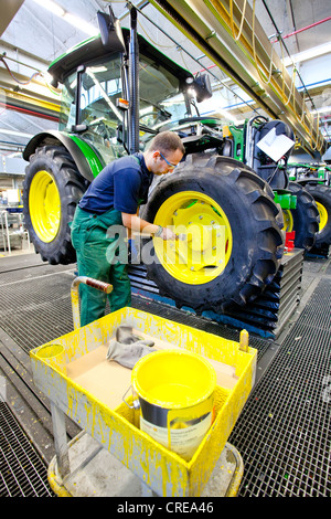 Les roues sont donné une couche de peinture dans la section production du tracteur au siège européen de l'American Agricultural Banque D'Images