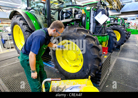 Les roues sont donné une couche de peinture dans la section production du tracteur au siège européen de l'American Agricultural Banque D'Images