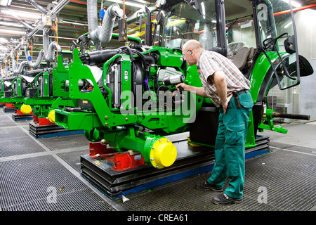 L'inspection finale, l'homme à la recherche d'une fuite avec une lampe UV dans la section production du tracteur au siège social européen de la Banque D'Images