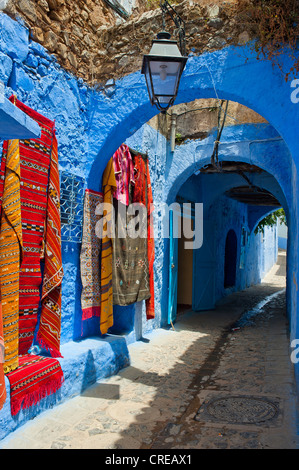 Un tapis tapis de vendre dans une ruelle dans la vieille ville ou Médina, Chefchaouen, Maroc, Afrique Banque D'Images