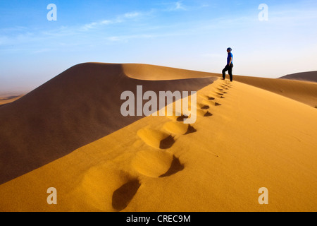 Femme marche dans les dunes, de l'Erg Chegaga, région Sahara près de Mhamid, Maroc, Afrique Banque D'Images