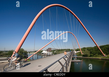 Cycliste sur le pont en arc en acier rouge sur le Rhine-Herne-canal au parc Nordstern, Allemagne, Rhénanie du Nord-Westphalie, région de la Ruhr, Bochum Banque D'Images