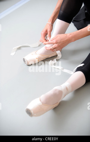 Un danseur de ballet se desserre les rubans sur ses chaussures Banque D'Images