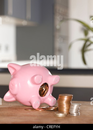 Piggy bank with coins on table Banque D'Images