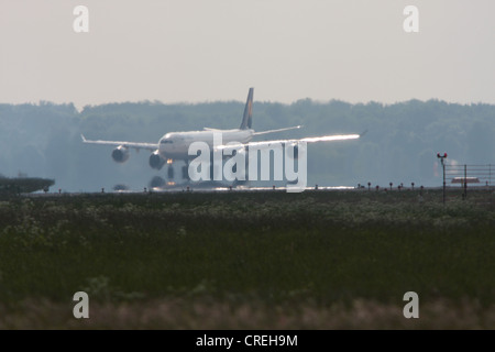 L'atterrissage Airbus 340 avec mirage et Brume de chaleur sur l'aire de manœuvre, l'Allemagne, la Bavière Banque D'Images