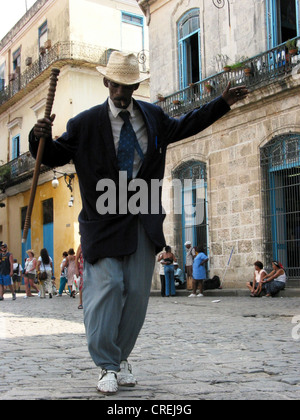 Homme danser dans les rues de la vieille ville, avec le bâton, hat et de cigare, Cuba, La Habana Banque D'Images