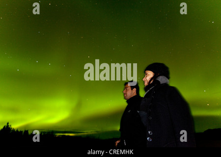 Couple, femme et homme, regardant tourbillonner Northern Lights, aurores polaires, Aurora Borealis, vert, près de Whitehorse Banque D'Images