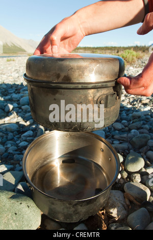 La sauvegarde du pain sur un feu de camp, mettant le petit pot dans le grand pot, grill, camping, Wind River, Territoire du Yukon, Canada, Banque D'Images