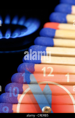 Ligne de tête bleu correspond à un rouge-tête match entre eux, à côté d'une cuisinière à gaz avec flamme fade dans le temps 'cinq avant douze Banque D'Images