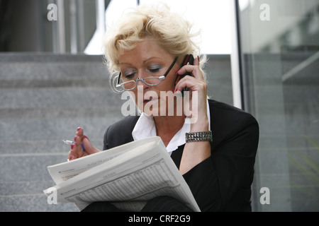 L'étude de la dame d'affaires appelant des actions Banque D'Images