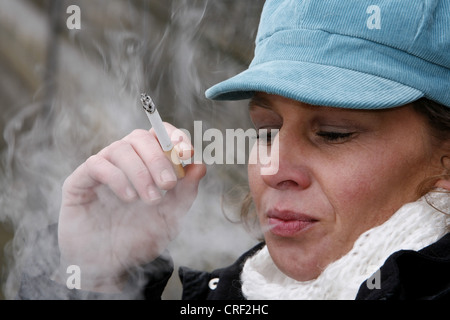 Une femme autour de 40 fumeurs cigerette Banque D'Images