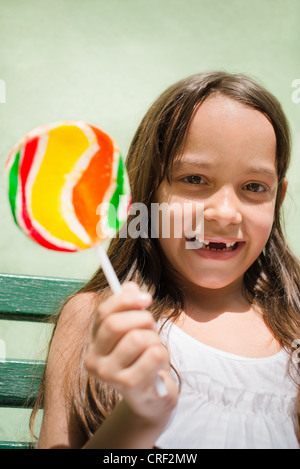 Portrait of cute little Girl with candy smiling and looking at camera Banque D'Images