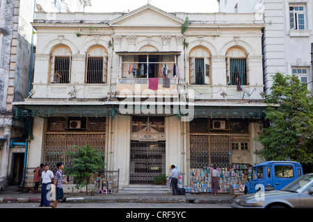 Le Myanmar, Birmanie, Yangon. Architecture de l'époque coloniale. Pansodan Street. Livres d'occasion à vendre, le séchage des vêtements. Banque D'Images