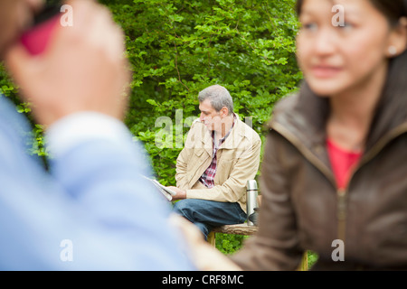 Man reading newspaper in park Banque D'Images