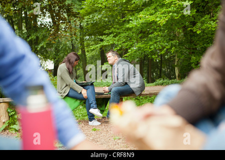 Couple reading clipboard in park Banque D'Images