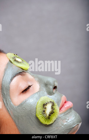 Femme avec masque et la peau de kiwi baignoire Banque D'Images