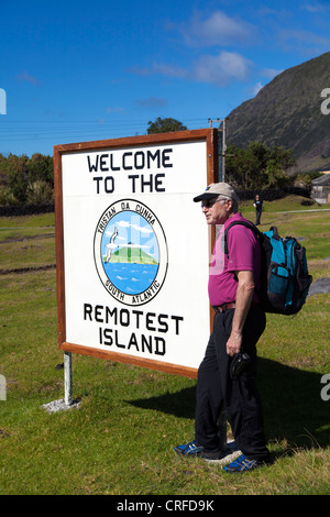 Homme posant à la bienvenue à l'île les plus reculés signe, Tristan da Cunha Banque D'Images