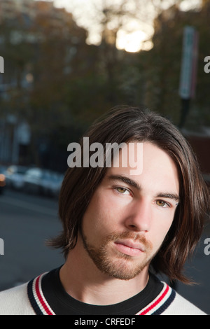 Portrait d'un élégant jeune homme aux cheveux longs Banque D'Images