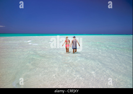 Couple dans l'eau de plage de Fort George Cay, une île inhabitée. Îles Turques et Caïques. Banque D'Images