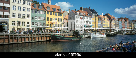 Copenhague, Danemark NYHAVN. Le nouveau port avec bateaux amarrés, bateaux de touristes et de terrasses de cafés, restaurants et bars. Banque D'Images