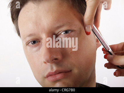 Homme à coiffure. La femelle coiffure utilise un rasoir Banque D'Images