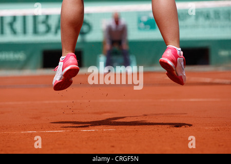 Pieds d'un joueur de tennis féminin de saut en l'air. Banque D'Images