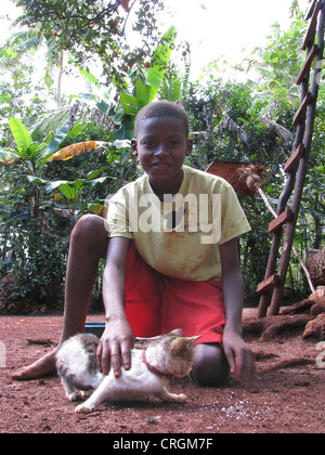 Garçon en zone rurale, en jouant avec un chat, échelle en bois, Haïti, Grande Anse Banque D'Images