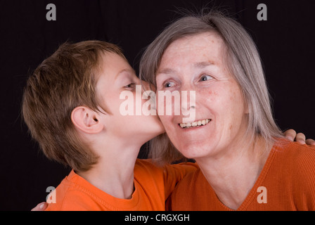 Petit-fils met un smoochy sur grand-mères joue Banque D'Images