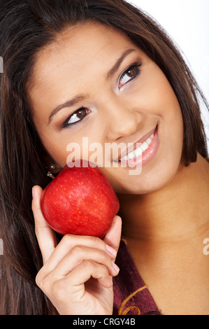 Young attractive darkhaired femme avec les yeux bruns et une pomme rouge, smiling Banque D'Images