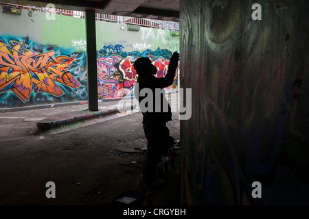 L'artiste graffiti sinistres murs sprays silhouette en passage sous tunnel à Waterloo. Banque D'Images