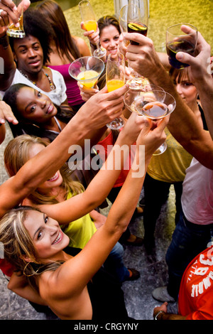 Groupe d'amis heureux dans un bar ou une discothèque à élever leurs verres Banque D'Images