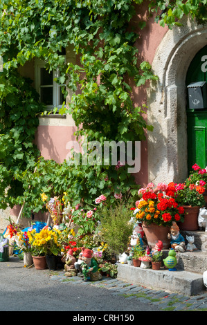 Fleurs, plantes en pot et les nains de jardin à l'extérieur d'une maison dans un village en Allemagne Banque D'Images