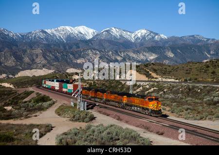 La Burlington Northern Santa Fe en train de conteneurs Cajon Pass, CA, avec les montagnes San Gabriel en arrière-plan. Banque D'Images