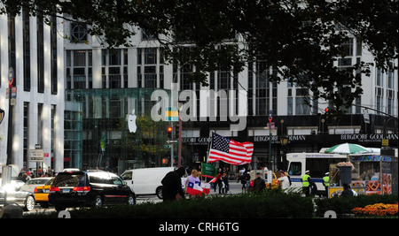 Voir, à l'Apple Store, le trafic, les gens, American flag flying blocage trottoir, 5e Avenue, Central Park South, New York Banque D'Images