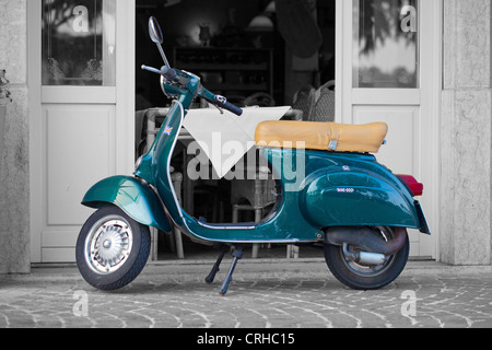 Éclaboussé de couleur bleu nostalgique Scooter stationné à l'extérieur d'un restaurant italien Banque D'Images