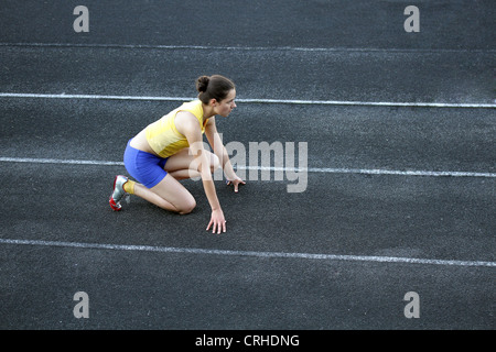 Athletic woman en position de départ sur la voie . Banque D'Images