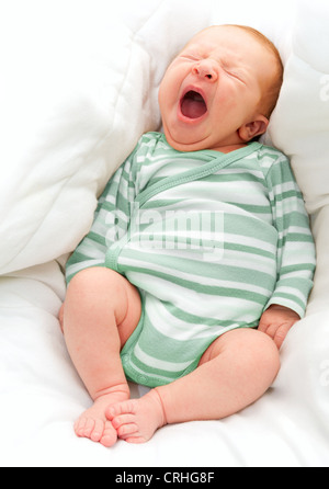 Les bâillements bébé nouveau-né dans le lit