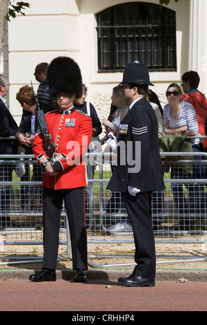 Guardsman debout parlant à un policier dans la région métropolitaine de la Mall London England Banque D'Images