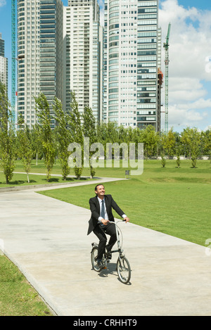 Woman riding bicycle in park Banque D'Images